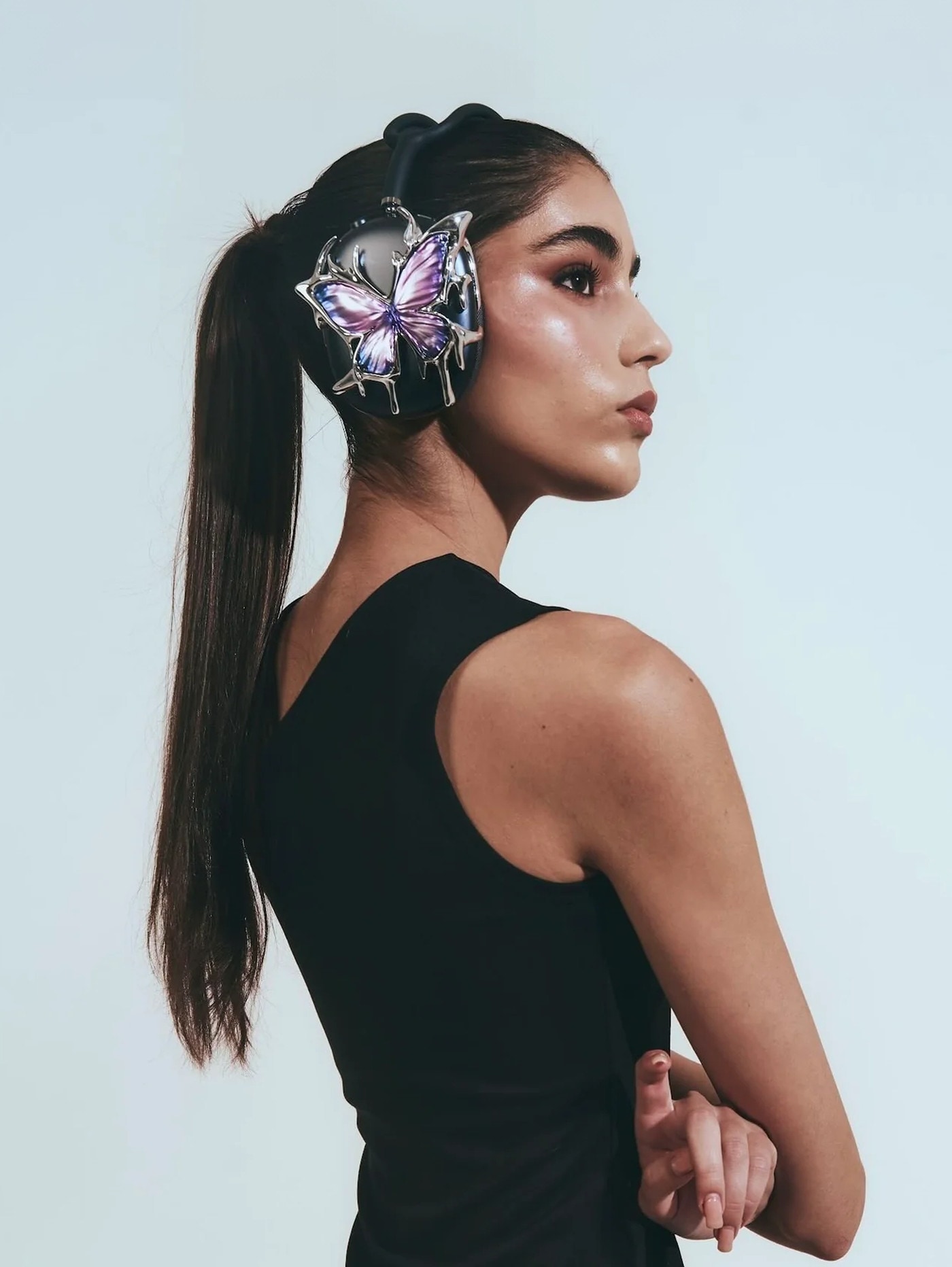 Model wearing headphones with the purple butterfly piece